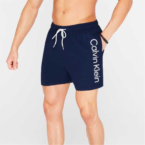 Мъжки плувни шорти и клинове Calvin Klein Large Logo Swim Shorts Морска синьо Calvin Klein Large Logo Swim Shorts Морска синьо Мъжки плувни шорти и клинове