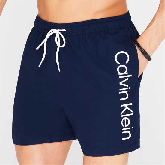 Мъжки плувни шорти и клинове Calvin Klein Large Logo Swim Shorts Морска синьо Calvin Klein Large Logo Swim Shorts Морска синьо Мъжки плувни шорти и клинове