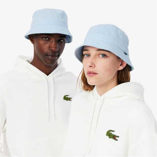 Шапки с козирка Lacoste Рибарска Шапка Bucket Hat Sn52 Светлосин Lacoste Рибарска Шапка Bucket Hat Sn52 Светлосин Шапки с козирка